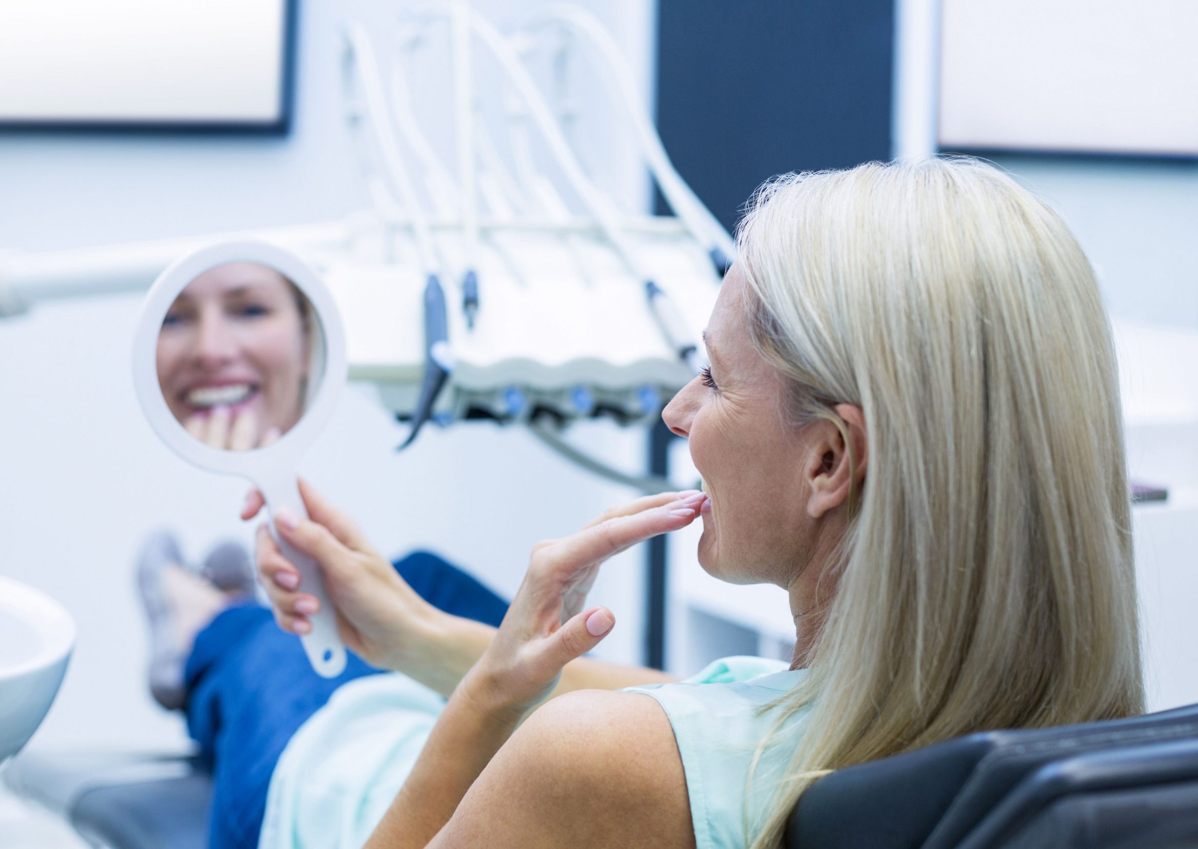 dental implant patient looking at teeth after procedure